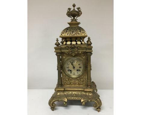 A large brass cased Victorian mantel clock with a dome top and ornate pillars. Height 56cm