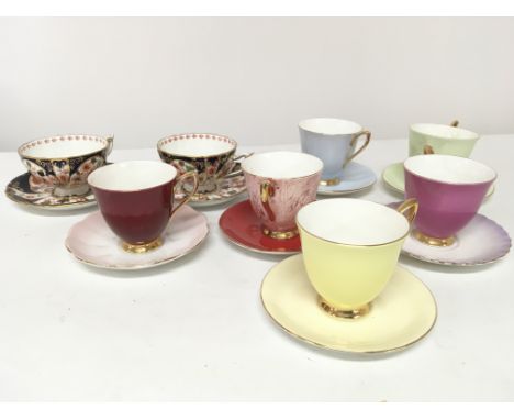 A pair of Royal Crown Derby Porcelain Imari pattern cups and saucers and a part set Royal Albert bone china harlequin tea set