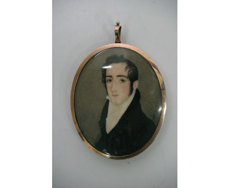 An oval miniature portrait of a gentleman with memorial to reverse. Mounted in a gold tone case, approx portrait size 7cm.