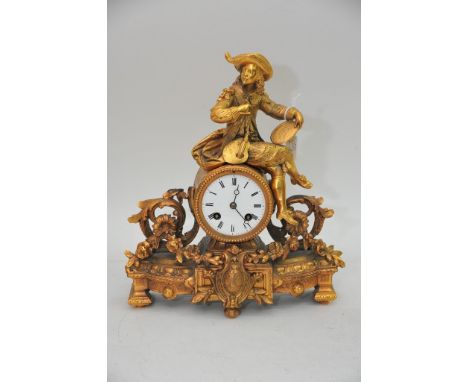 A French gilt mental clock with roman numerals, ornately decorated with a painter perched on the top of the clock and traditi
