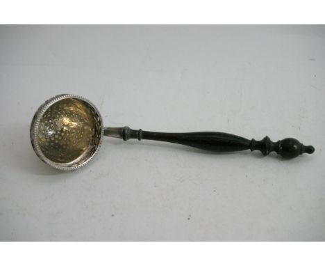 A continental silver straining ladle with turned wood handle. stamped 925 with import marks. Approximately 16cm long