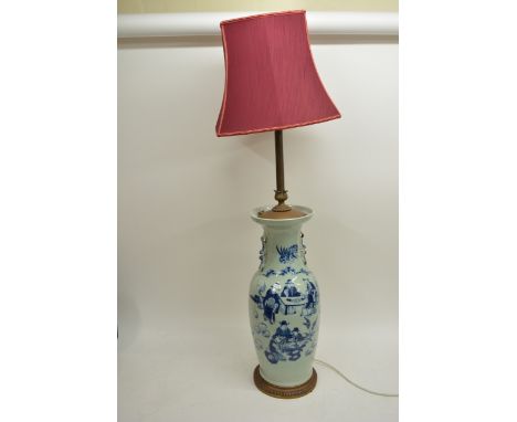 An Oriental blue and white vase converted in to table lamp and depicting figures in a garden setting, 124cm with shade.