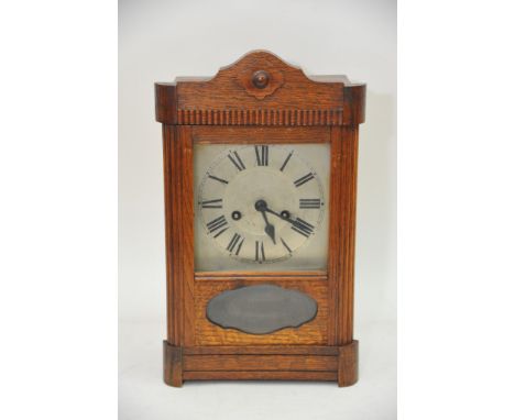 An oak cased 8 day clock with silvered dial and Roman numerals, approx height 38.5cm.