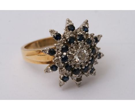 An 18ct yellow gold ring set with a large sapphire and diamond cluster. Approximately size V