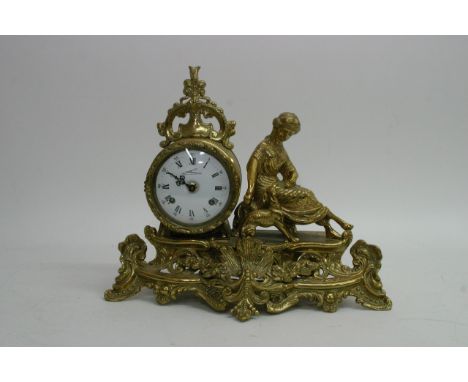 An eight day brass figural clock with white enamel dial and Roman numerals by Franz Hermle.