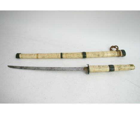 A Japanese bone Katana, the scabbard with carved warriors