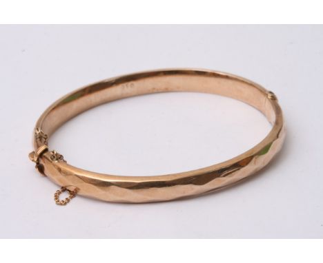 A 9ct gold bangle with argyle styled pattern and safety chain