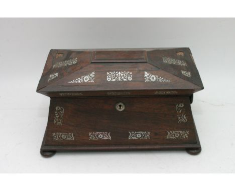 A rosewood tea caddy with mother of pearl inlays.