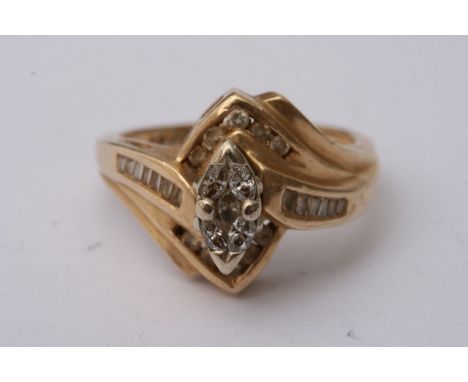 A 14ct gold ring set with a pear shaped diamond flanked by baguette cut examples. Approximate size 0