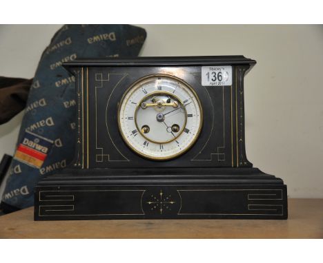 A slate Victorian mantle clock with roman numerals and visible escapement