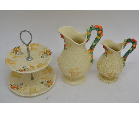 Clarice Cliff harvest pattern ceramics comprising two jugs and a cake stand
