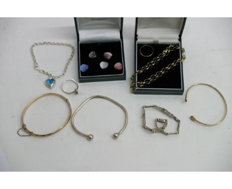 A collection of gold and silver jewellery including a 9ct gold bangle, gold ring, necklace and other items.