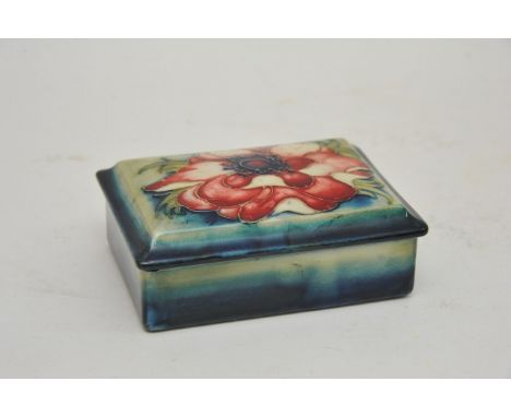 A Walter Moorcroft Anemone pattern trinket box, full signature and paper label to base. Approximately 9x12cm