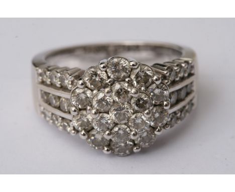 A 14ct white gold diamond ring set with a central circle of diamonds flanked by three bands to each side.Made by Australian m