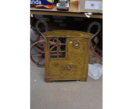 An Arts and Crafts style brass firescreen decorated with a bat