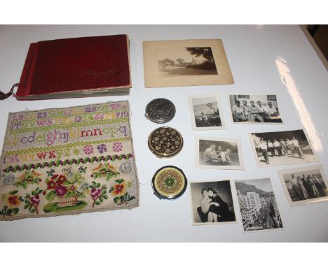 A box containing compacts, a sampler, photo album and other ephemera