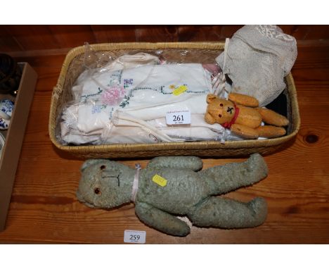 A basket containing various vintage bears, dolls dresses etc.