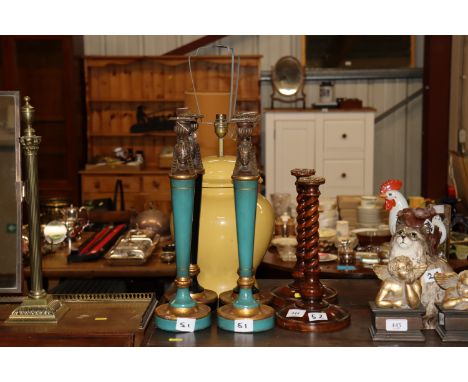 A pair of barley twist candlesticks; two pairs of Egyptian decorated candlesticks and a glazed table lamp