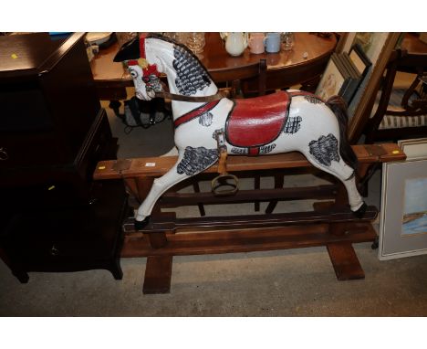 A painted rocking horse on wooden stand 
