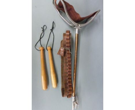 A vintage shooting stick together with a brown leather 12 bore shotgun cartridge belt and a wooden priest.&nbsp;