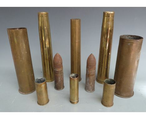 Eight brass shell casings including British six pounder dated 1916 and a German 1917 example, together with other smaller cal