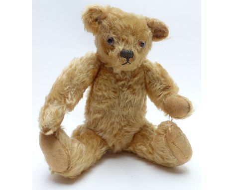 Vintage straw-filled Teddy bear with blonde mohair, glass eyes and jointed limbs, 29cm tall.&nbsp;