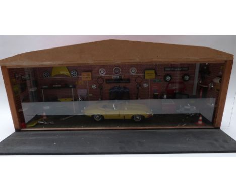 A scratch built 1:18 scale workshop or garage diorama fitted with electric lights featuring an e-type Jaguar and various part