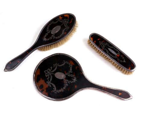 A silver and tortoiseshell three-piece dressing table set, London 1917 (3).Condition ReportNo losses to the silver inlay, the