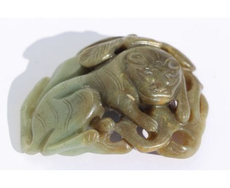 A Chinese jade / hardstone buckle in the form of a tiger beneath a tree, 9cms wide.