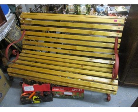 A garden bench with red painted supports 