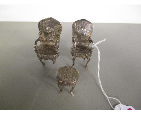 A pair of Dutch silver miniature chairs, along with a Chinese silver dolls house table marked WP90 and with Chinese calligrap