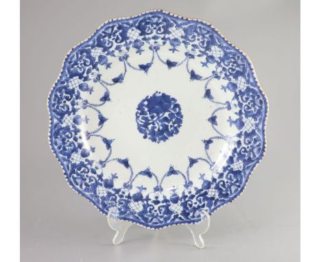 A Chinese porcelain charger, Qing dynasty, mid 18th century, painted in underglaze blue with a central flower spray within a 