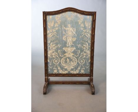 An Edwardian parcel gilt simulated bamboo fire screen, inset with an arched Lyonnaise silk panel with a dancing nymph within 