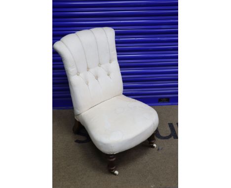 A Victorian walnut framed button back nursing chair, on turned legs, with brass and ceramic castors, height 79cms width 47cms
