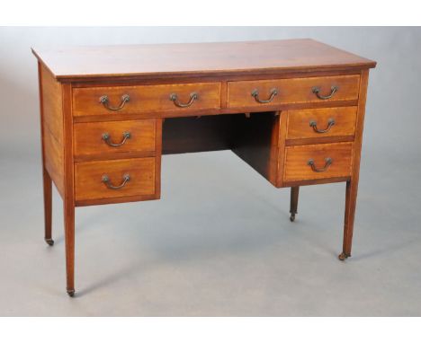 An Edwardian satinwood banded mahogany dressing table, fitted six drawers on squared tapered legs, fitted ceramic castors, W.