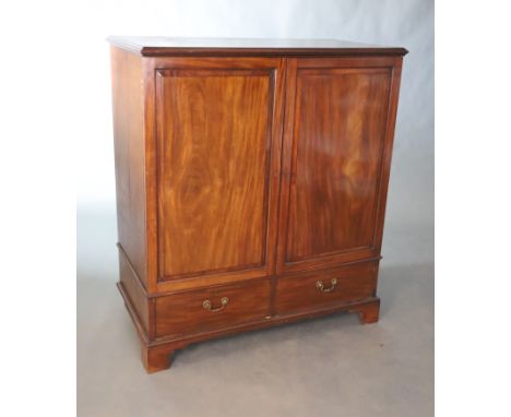 A George III mahogany press cupboard, with moulded cornice above a pair of panelled doors and two short drawers, on bracket f