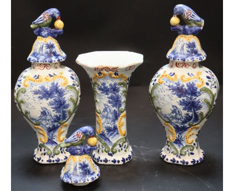 A 19th century Dutch delft polychrome part garniture of three vases, painted in blue with musicians, the domed covers with pa