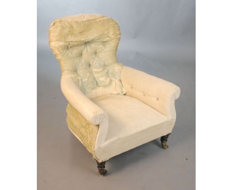 An early Victorian ebonised oak deep seated button back armchair, with distressed upholstery and turned legs, fitted brass ca