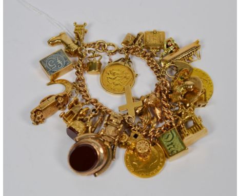 A charm bracelet, each link stamped '9' '.375', hung with twenty nine charms, including a 1913 half sovereign, an anchor, a s