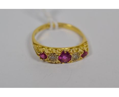 A ruby and diamond five stone ring, stamped '750', finger size P1/2.  Gross weight 4.5 grams. 