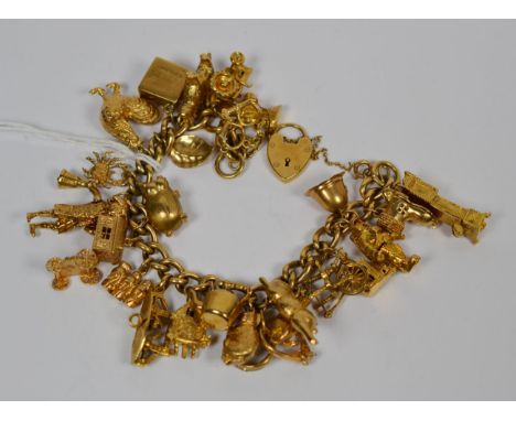 A curb link bracelet, each link stamped '9' '.375' with a padlock clasp, and hung with twenty five charms, including a long c