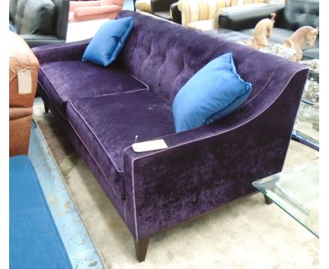 SOFA, two seater, in buttoned purple velvet on square ebonised supports, 196cm L plus two scatter cushions.