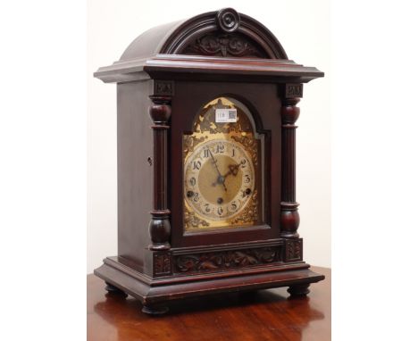 Edwardian stained carved arched top bracket clock with brass Arabic dial and bevelled glass door with columns, triple train m