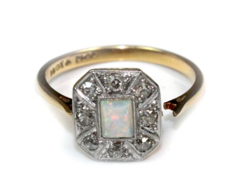 An opal and diamond cluster ring, early 20th century, the rectangular cabochon opal within an eight-stone border of old-cut d