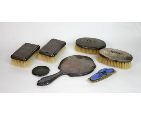 A pair of Art Deco silver mounted oval Military hair brushes, London 1936, applied with initials 'D.W.', and spot hammered, a