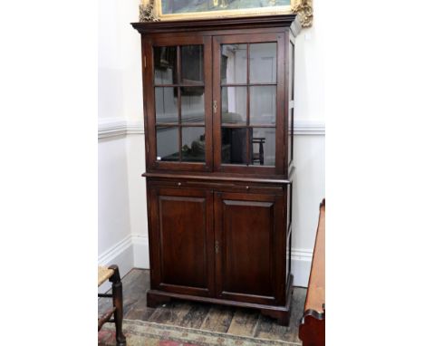 A reproduction George III style oak cupboard, by 'The Real Wood Furniture Company, Woodstock, Oxford', the upper part with ad