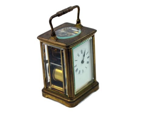 A French brass cased carriage clock, circa 1900, striking on a gong, the white enamel dial with Roman numerals and indistinct