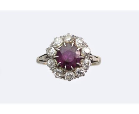 An early/mid 20th century gold, ruby & diamond cluster ring, centred with a round-mixed-cut ruby approx. 1.02cts, claw set wi