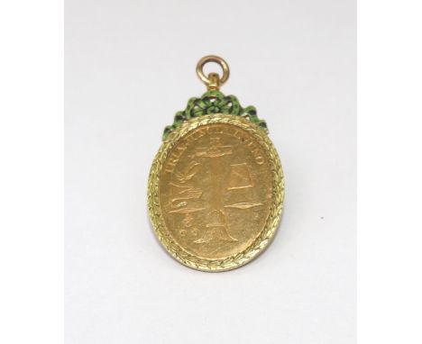A 19th century gold and enamel oval pendant with a laurel chased border and green and black enamelled flower and ribbon surmo