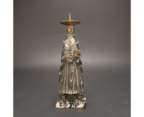 Candle Stick in Gothic Manner, standing cleric, holding a book. In folded dress. On top octagonal tazza with peak. Partly bro